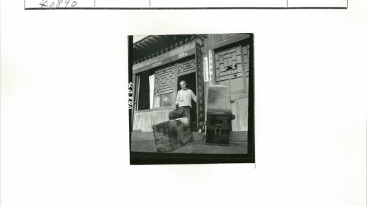 手持木箱的男子与木窗建筑.jpg