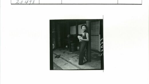执扇妇女与古建筑前.jpg