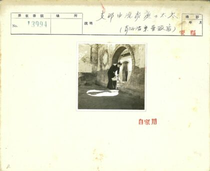 拱门砖墙前倒水的人.jpg