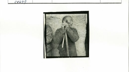 持棍男子凝视纹理墙.jpg