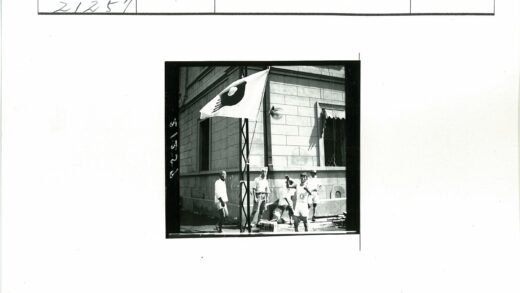旗杆前男子持鸟众人围观.jpg