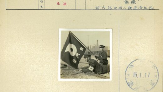 日本制服人员铁路旁举旗.jpg