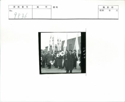 日本国旗西装男子集会砖房前.jpg