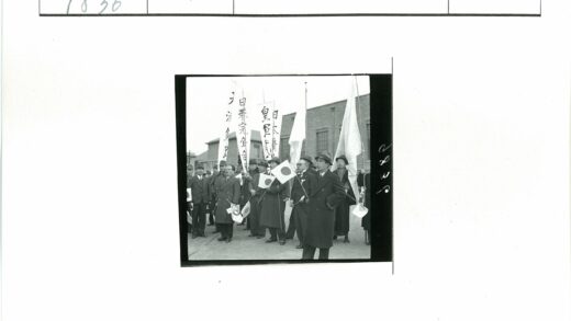 日本国旗西装男子集会砖房前.jpg