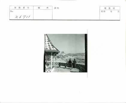 木凳旁俯瞰海岸线与传统建筑.jpg