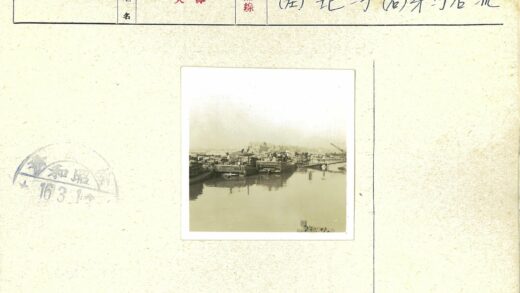 木船停靠河岸与城市远景.jpg