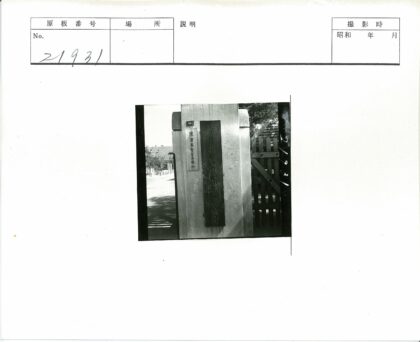 木门旁刻字石柱与斜顶建筑.jpg