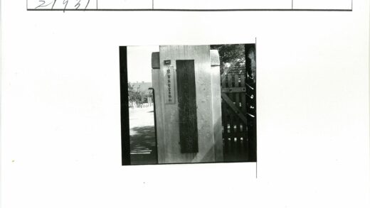 木门旁刻字石柱与斜顶建筑.jpg