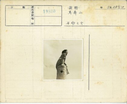 格子裙女子坐石柱多云背景.jpg