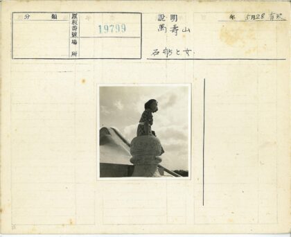 格子裙女子站古老石建筑.jpg
