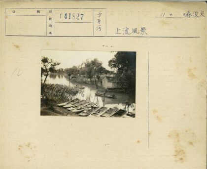 河边划艇与绿树小房景色.jpg