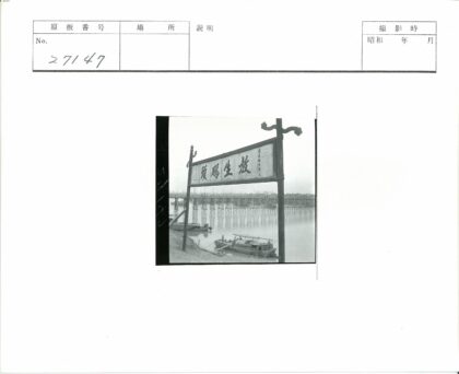 河边汉字牌与高架木桥船影.jpg