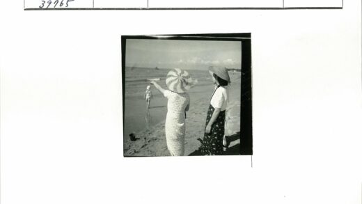 海边戴帽女人与孩童沙滩时光.jpg