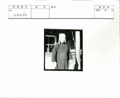 深色外套白巾人站建筑窗前.jpg