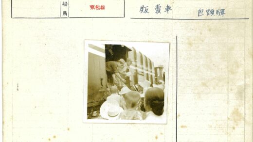 火车入口分发文件的男子与戴帽人群.jpg