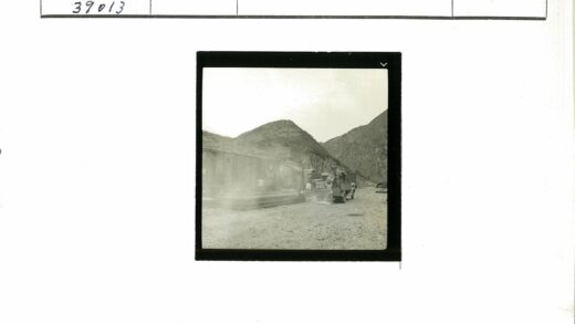 火车旁卡车人群与群山背景.jpg