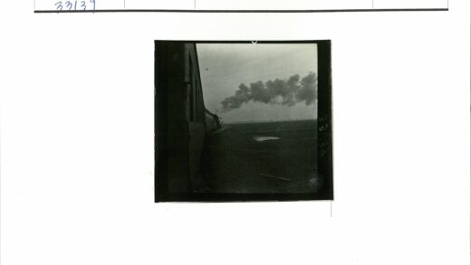 火车行驶铁轨旁池塘浓烟天空.jpg
