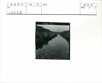 灰色天空下岩石溪流山丘.jpg