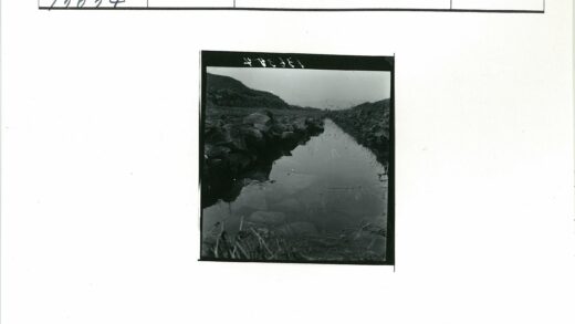 灰色天空下岩石溪流山丘.jpg