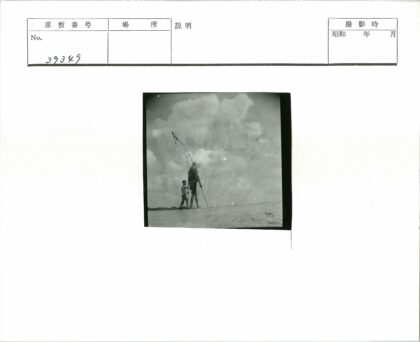 父与子沙滩漫步持长杆.jpg