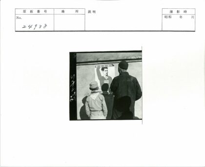 父子凝视墙上人物海报.jpg