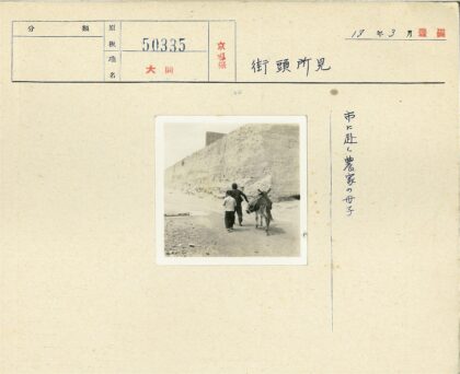 父子牵驴行于石墙小路.jpg