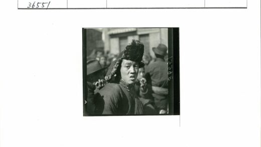 独特帽子大衣人站建筑前.jpg
