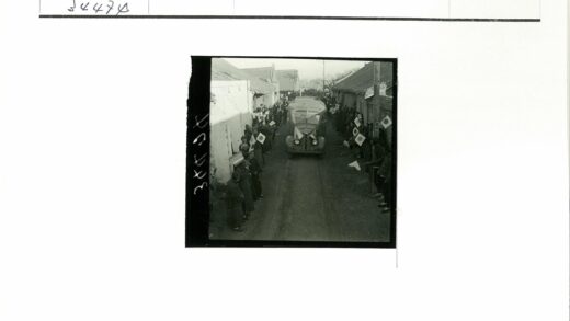 狭窄街道汽车驶过两旁旗帜建筑.jpg