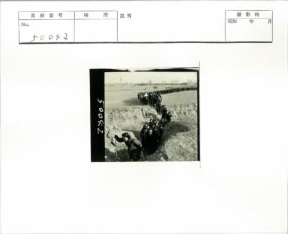 田野行军队伍与远方建筑.jpg