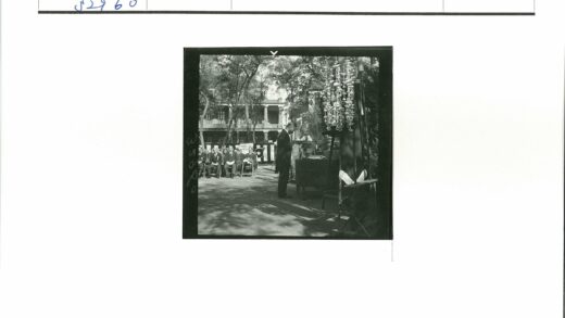 男人桌前多人树荫下多层建筑.jpg