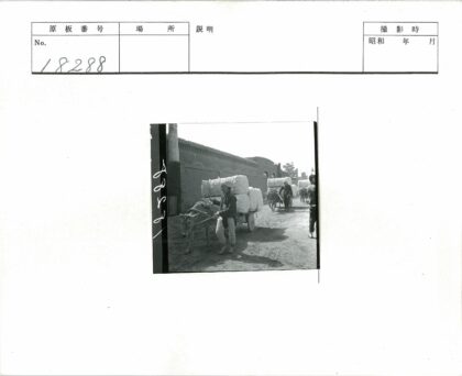 男人牵驴车穿过狭窄土街.jpg