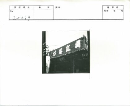 男子与店铺顶棚大字合影.jpg