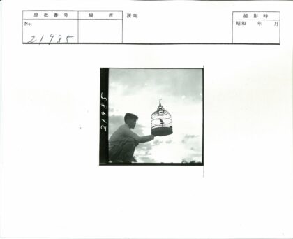 男子与笼中鸟的阴天背影.jpg