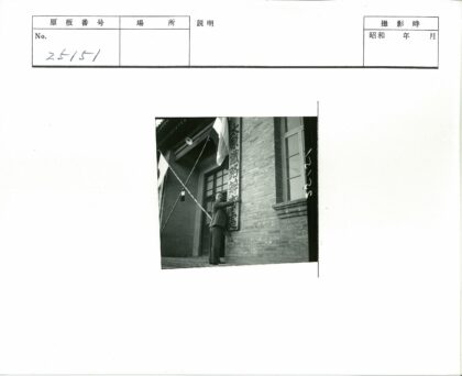 男子举标站砖建筑旗帜下.jpg