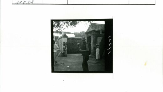 男子庭院持鸡腿石墙背景.jpg