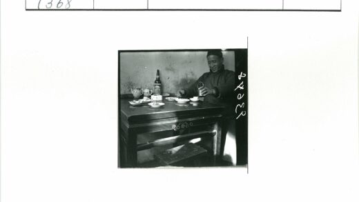 男子微笑持杯室内餐桌.jpg