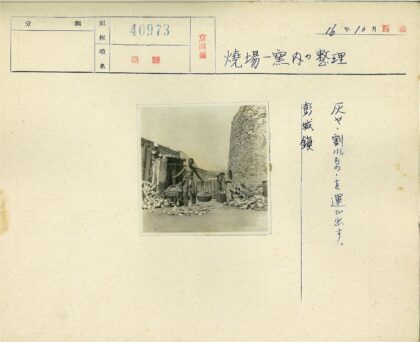 男子扛竹竿站石砌建筑旁.jpg