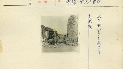 男子扛竹竿站石砌建筑旁.jpg