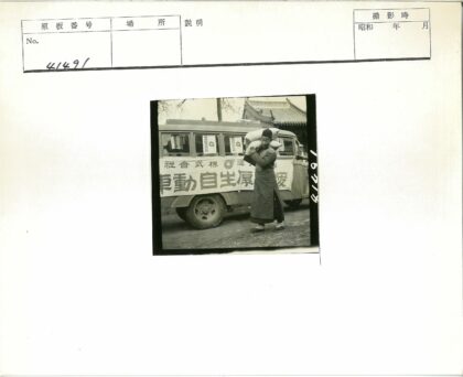 男子扛麻袋站在标语公交车前.jpg