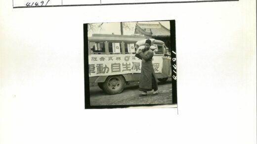 男子扛麻袋站在标语公交车前.jpg