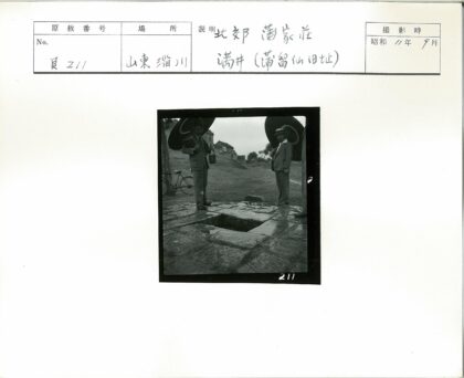 男子持伞站石洞旁湿地背景自行车.jpg