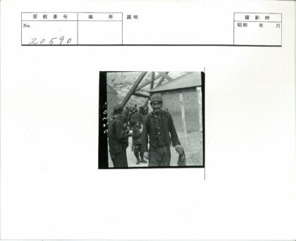 男子持包裹与人群在岩石景观前.jpg