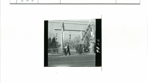男子持横幅走过鸟居.jpg