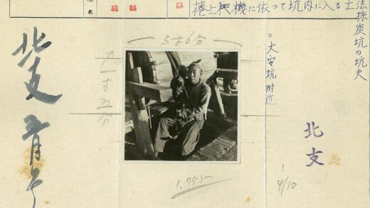 男子持绳站木轮旁.jpg