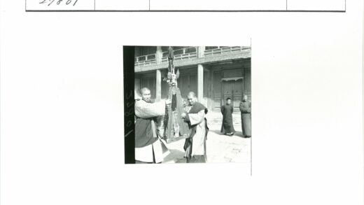 男子持骷髅三角物木屋前合影.jpg