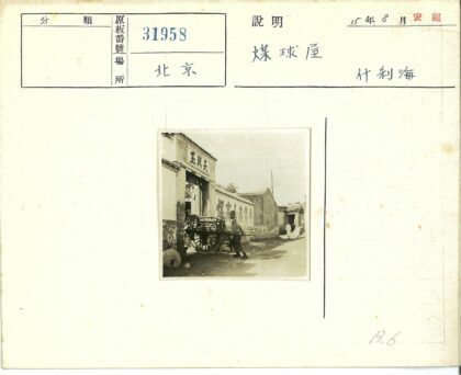 男子推木车穿过汉字大门街景.jpg