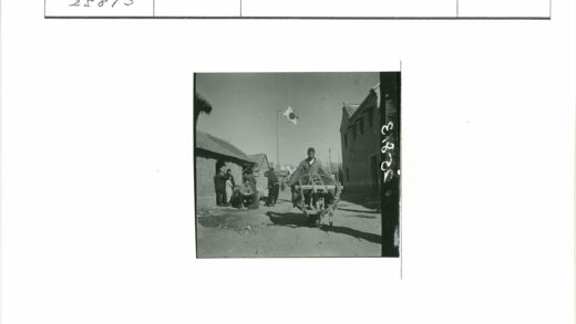 男子推车人群聚集建筑旗帜.jpg