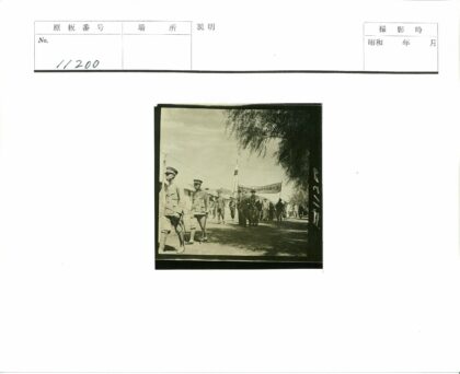 男子游行队伍走过土路横幅飘扬.jpg