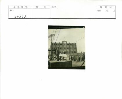 男子演讲砖砌建筑前人群.jpg