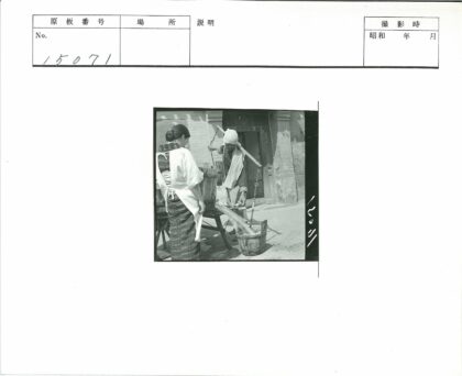 男子用轭挑水妇女旁观.jpg